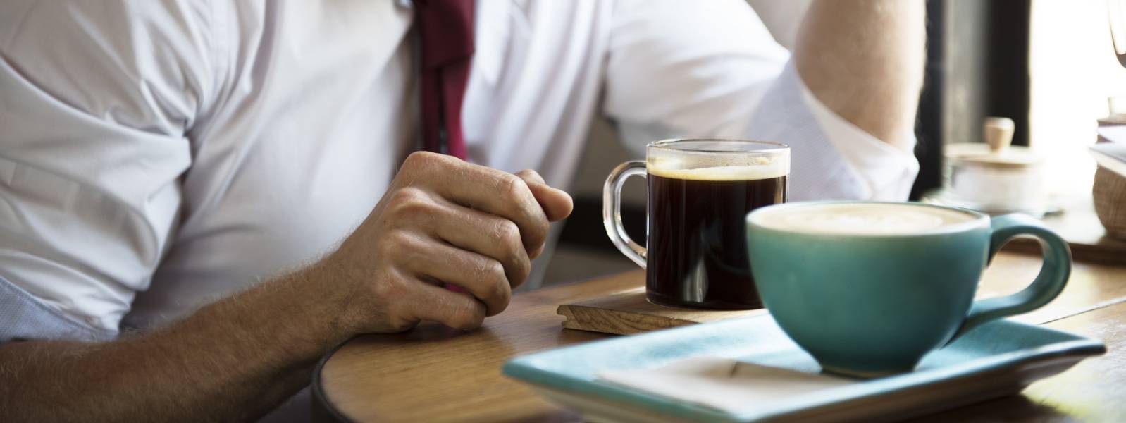 businessman drinking coffee mug high amounts of caffeine exacerbate sleep deprivation